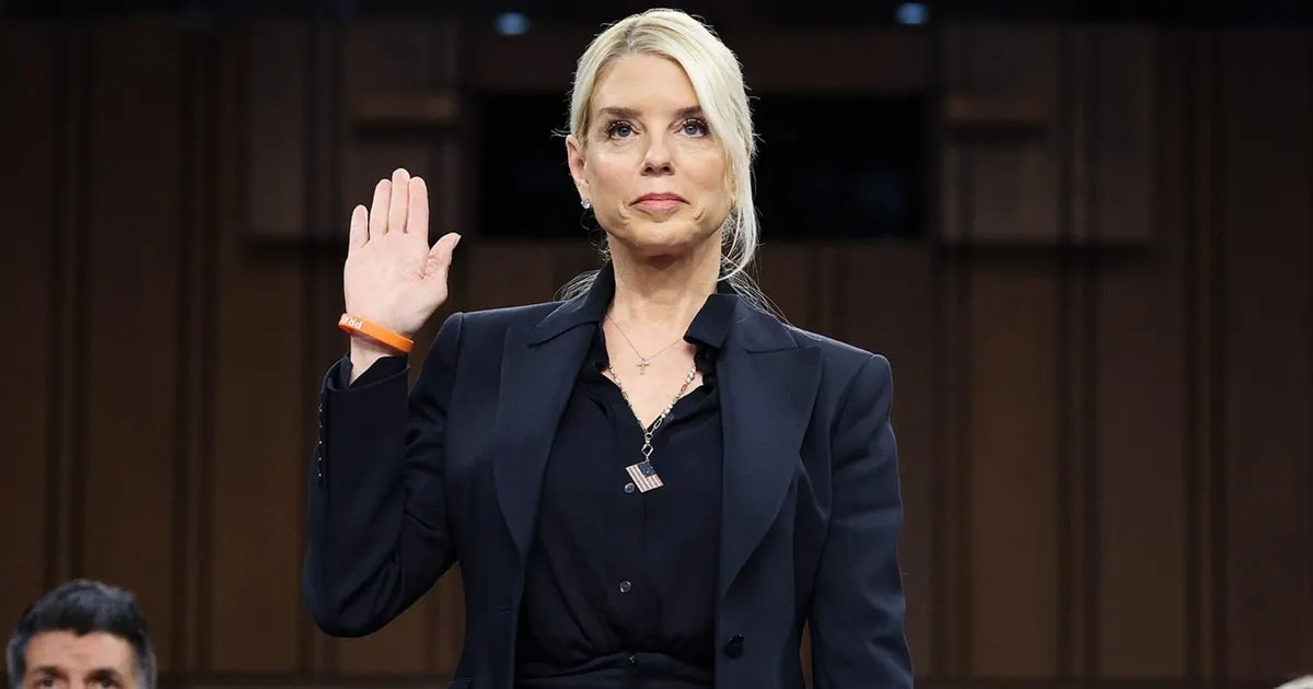 A person in a suit holding her hand up
AI-generated content may be incorrect.